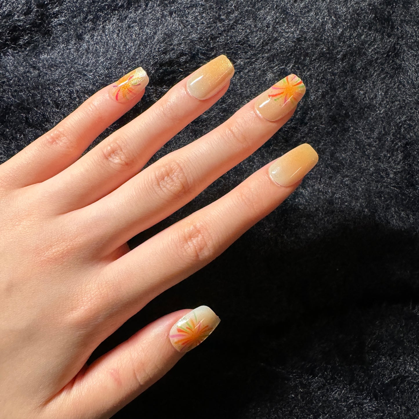 press-on nails / orange cat-eye fireworks